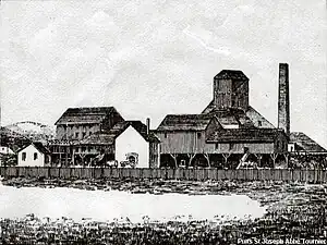 The workshops at the Saint-Joseph shaft; behind, the headframe and chimney c. 1884.