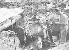 Soldiers in a gun pit with a mortar tube