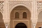 Marble capitals and stucco decoration of the portico and the doorways behind it