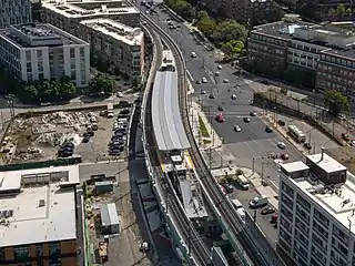 Aerial view of an under-construction rapid transit station in an urban square