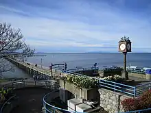 A square with a clock in it, in front of a beach