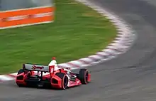 Photograph of Wilson in a Dallara DW12 Honda racing into a curve
