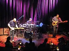 Three musicians performing on stage.