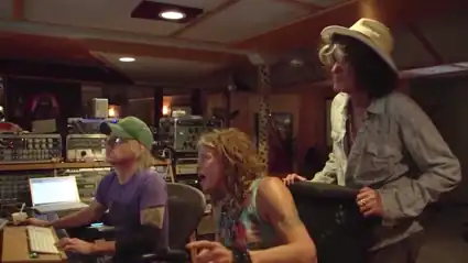 Sound engineer for Aerosmith sitting in the recording studio at the mixing board with Steven Tyler and Joe Perry of Aerosmith.