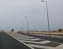 Turn off to Madinat Al Kaaban on Al Shamal Road