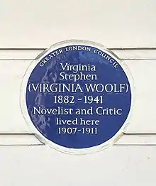 A photograph of the Virginia Woolf blue plaque at Fitzroy Square. It reads 'Virginia Woolf 1882-1941 Novelist and Critic lived here 1907–1911.'