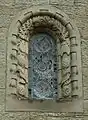 Stone window surround decorated with insects, birds and pinecones at St Mary's, Wreay